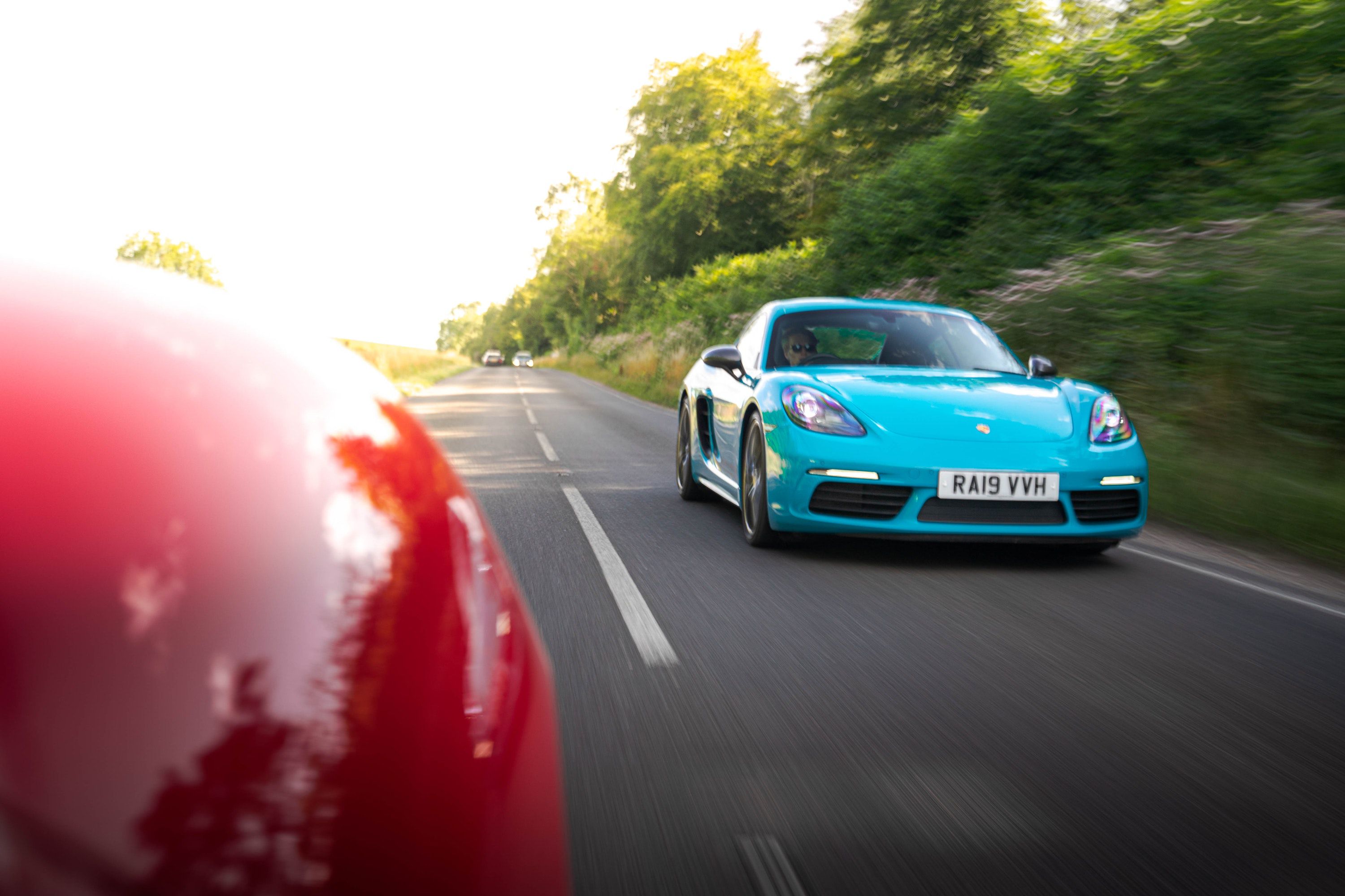 Porsche Cayman driving on a road